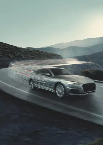 Bridgestone key visual with a sleek silver car speeds around a curvy mountain road, leaving light trails amid a serene mountainous backdrop